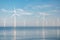 Offshore windmill park with stormy clouds and a blue sky, windmill park in the ocean