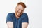 Oh stop it you. Portrait of cute pleased and satisfied happy and funny redhead man in blue t-shirt, shrugging and