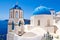 Oia Orthodox churches domes and the bell-tower. Santorini island, Greece.