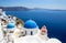 Oia town in Santorini, Greece.  Blue domed churches Agios Spyridonas and Anastaseos.