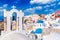 Oia village with famous white houses and blue churches on Santorini island, Aegean sea, Greece