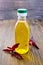 Oil with amaranth in bottle on dark board