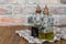 Oil and balsamic vinegar glass bottles with spouts on a napkin on rustic brick wall background with copy space
