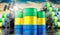Oil barrels with flag of Gabon and oil extraction wells - 3D illustration