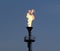 Oil burning torch against a blue sky