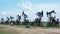 Oil derricks against cloudy sky