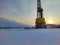 Oil drilling rig. Winter at dawn in the snow