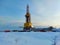 Oil drilling rig. Winter at dawn in the snow