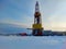 Oil drilling rig. Winter at dawn in the snow