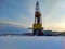 Oil drilling rig. Winter at dawn in the snow