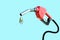 Oil dripping from a gasoline pump isolated on blue background - 3D Rendering.Fuel nozzle with hose fuel pump.Gas pump with drop of