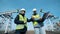 Oil extraction site with two workers having a conversation. Working oil pumps, oil rigs on a background.