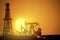 Oil field over sunset. Vector illustration. Gas industry. Dark silhouette drilling rig.