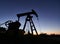 Oil field with petroleum pump jack under beautiful night sky.