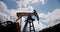 Oil Field Pump Jack Against Blue Skyand clouds.