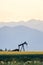 Oil field pump and mountain sunset