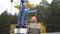 Oil field technical worker standing in front of crude oil pump unit. Engineer in orange helmet overseeing site of crude