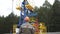 Oil field technical worker standing with his back to camera and in front of crude oil pump unit. Oilman in orange helmet