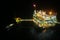 Oil and gas construction in night view. View from helicopter night flight. Oil and gas platform in offshore.