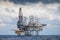 Oil and gas drilling rig working on remote wellhead platform to