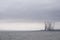 Oil and gas refinery industry at sea coast dock port under dark grey sky