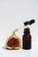 Oil in a glass bottle with a pipette. A bottle of fig oil with fresh fruit on a white background. Organic natural bio-oil.