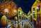 Oil painting - night evening city, yellow houses, white lights, people with umbrellas, wet road, reflection