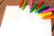 Oil pastel crayons lying on a paper with painted children\'s draw