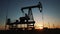 oil production. silhouette oil and gas production rig at sunset glare. oilfield business a extraction concept. oil