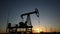 oil production. silhouette oil and gas production rig at sunset glare. oilfield business a extraction concept. oil