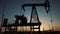 oil production. silhouette oil and gas production rig at sunset glare. oilfield business a lifestyle extraction concept