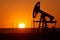 Oil pump on a sunset background. World Oil Industry.