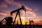 Oil Pumpjack against a sunset sky on background. industrial equipment. Rocking machines for power genertion. Extraction