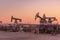 Oil Pumpjack against a sunset sky on background. industrial equipment. Rocking machines for power genertion. Extraction