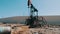 Oil pumpjacks in a working oil field in Baku, Azerbaijan.Silhouette of working oil pump and an old rusty iron barrel