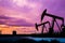 Oil pumps at oil field with sunset sky background