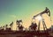 Oil pumps silhouette against sun - vintage retro style