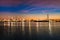 Oil refinery industry reflection on water at early morning under colorful sky of sunrise