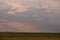 Oil refinery seen on the horizon on the wheat field at sunset