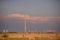 Oil refinery seen on the horizon on the wheat field at sunset