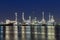 Oil refinery at twilight with river reflexion