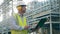 Oil refinery worker in safety wear is using a laptop during planning