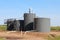 OIl Storage Tanks in a Corn field south of Alden Kansas USA out in the country with blue sky.