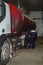 An oil tanker is undergoing maintenance at a service station