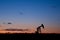 Oil well pumpjack sunset silhouette