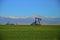 Oil Wells, Pump Jack , corn field and Mountains