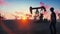 Oil worker inspects oil pumps at sunrise on the background of cloudless beautiful sky. 3D Rendering