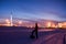 Oil worker in oilfield. Pump jack and engineer on a winter sunset sky background. Western Siberia.