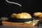 Oiling raw Hasselback potatoes before baking on dark grey table