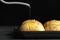 Oiling raw Hasselback potatoes before baking on dark grey table, closeup